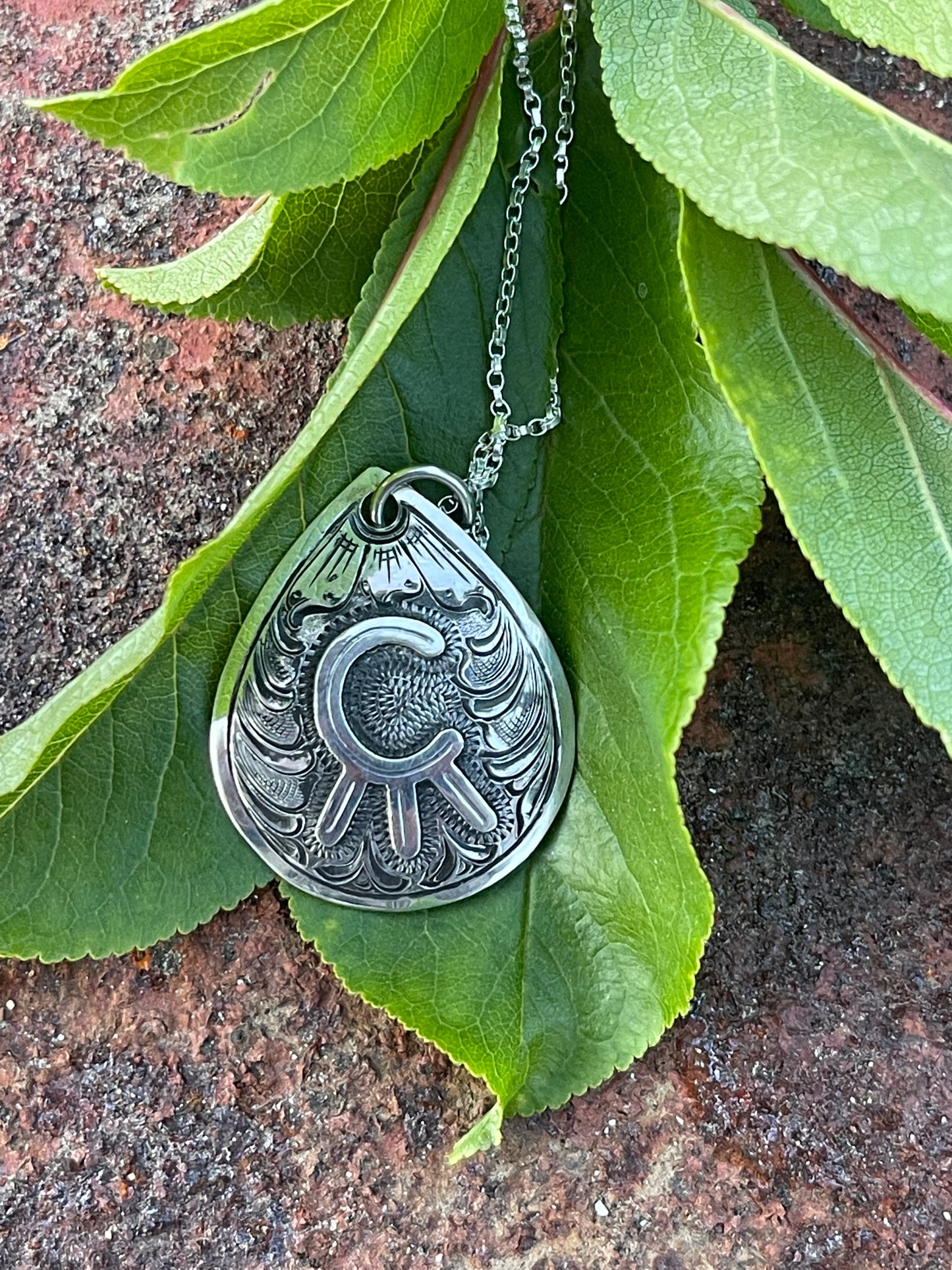 sterling silver pendant with a brand, antique finish