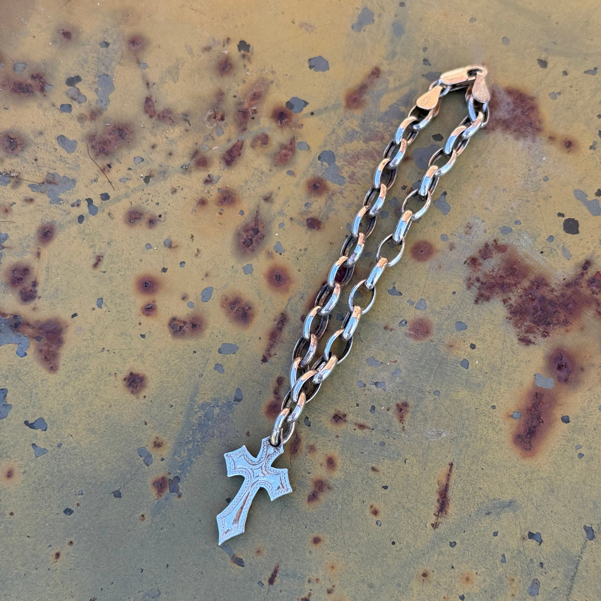 Hand-engraved sterling silver link bracelet with a small cross charm