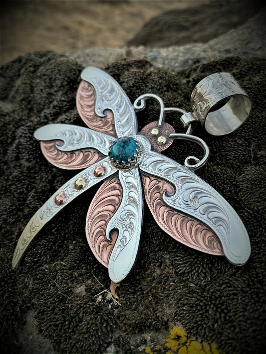 close up of sterling silver, copper and brass dragonfly with turquoise cabochan