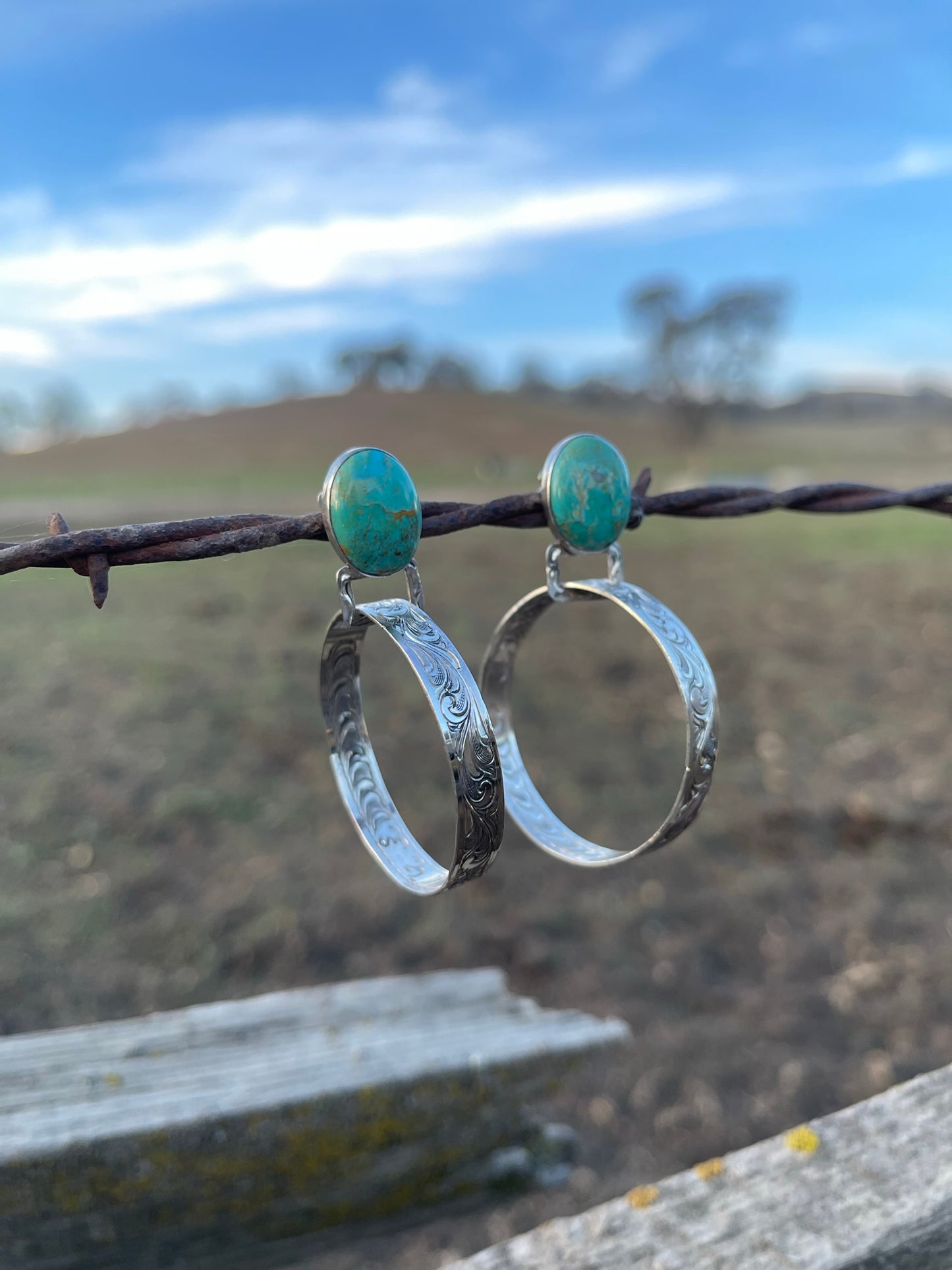 close up of turquoiose post earrings with sterling silver hand engraved hoops
